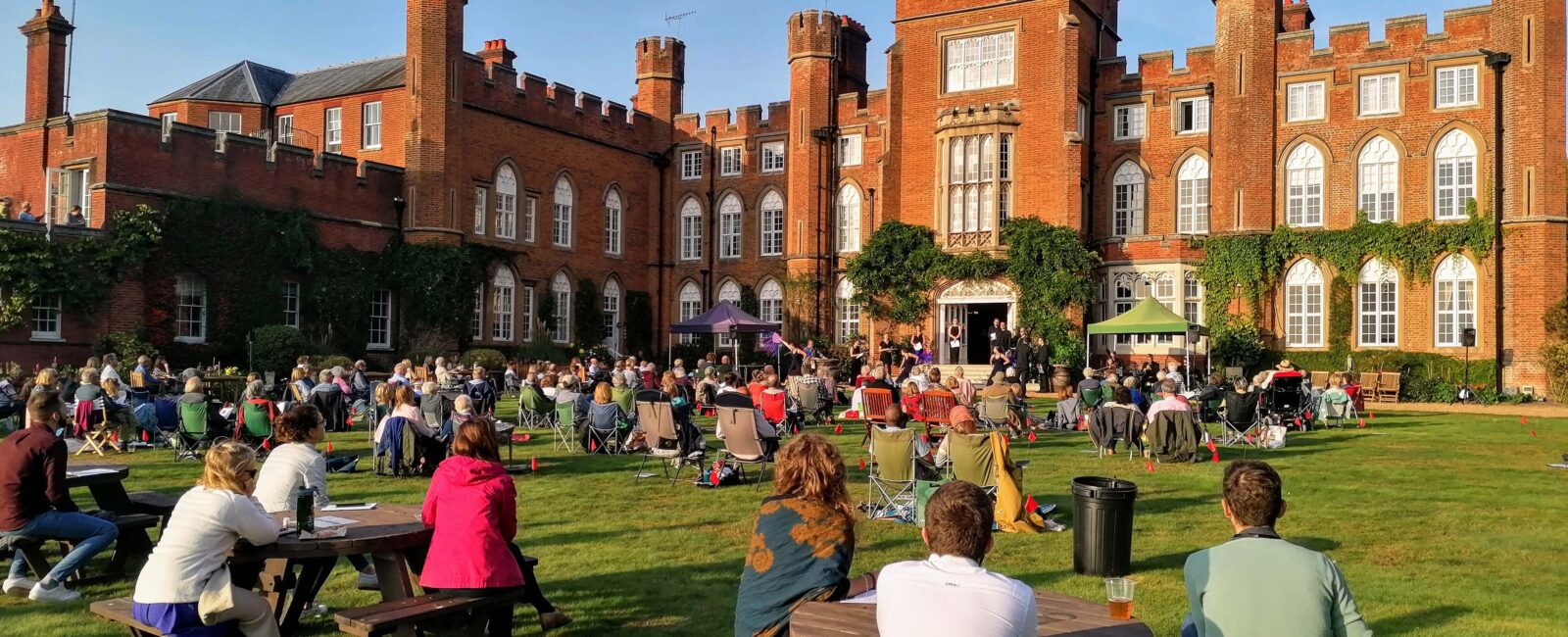 Guests watching 'Conference of the Birds' in the grounds of Cumberland Lodge