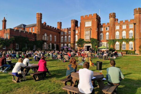 Guests watching 'Conference of the Birds' in the grounds of Cumberland Lodge