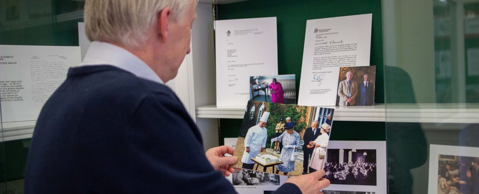 Chief Executive Dr Ed Newell adds a photo of the Queen to the exhibition cabinet