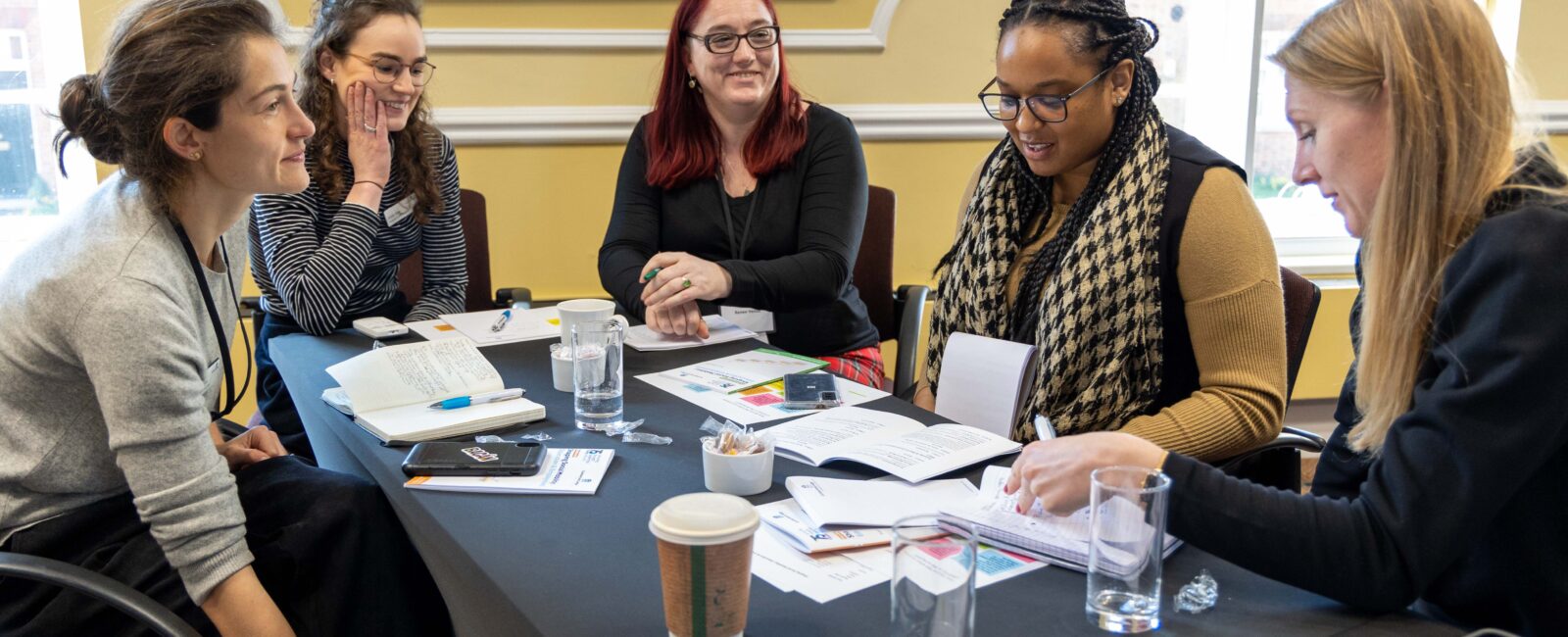 Students gathered around a table at an acedemic writing retreat