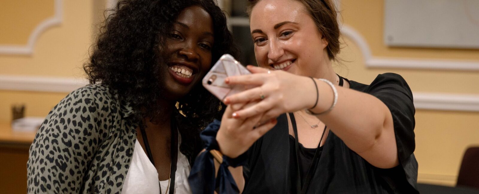 Cumberland Lodge Fellows Caroline Onyuka and Eleanor Clarke taking a selfie in the Flitcroft conference room.