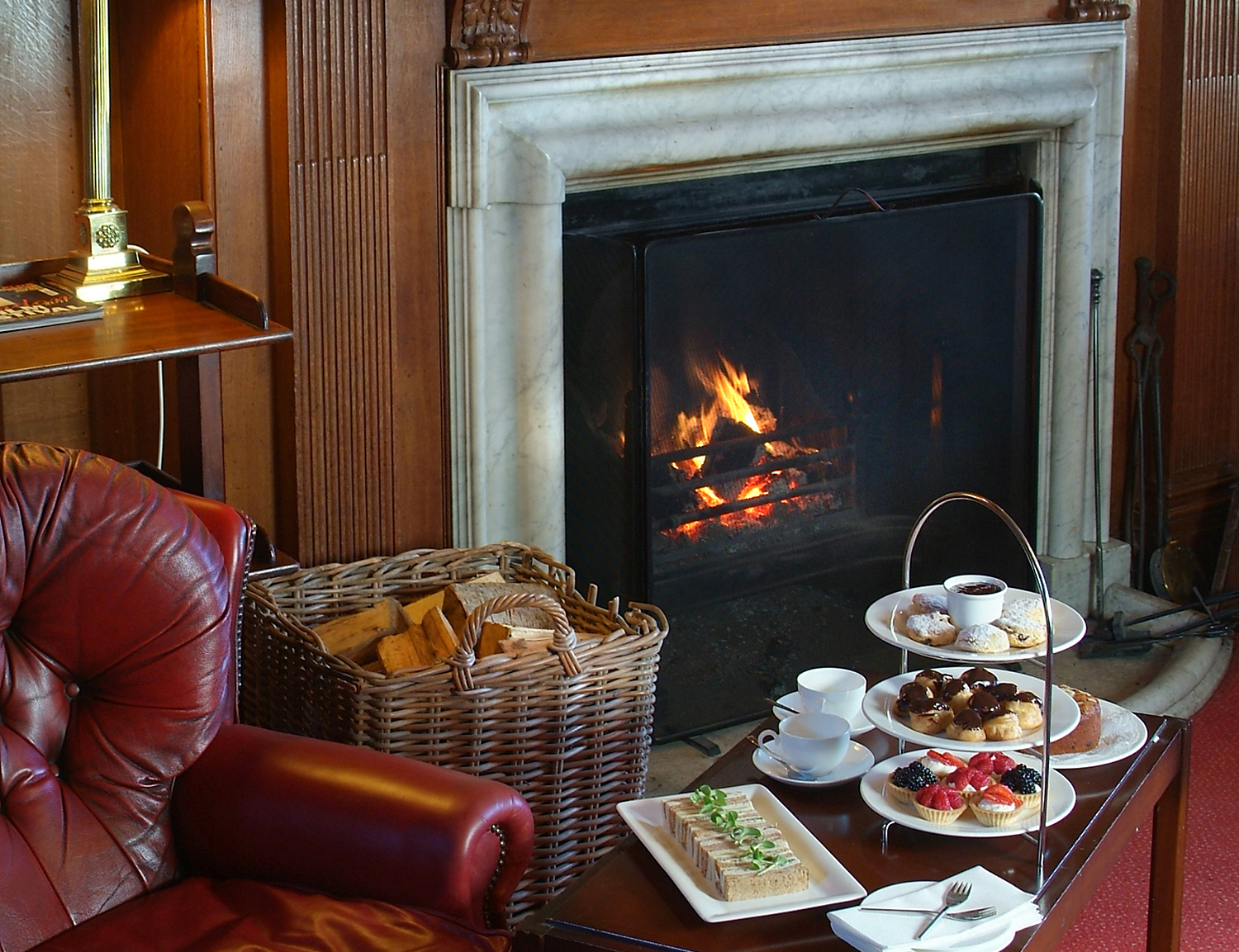 A close up of the fireplace in the Tapestry Hall, featuring an afternoon tea.