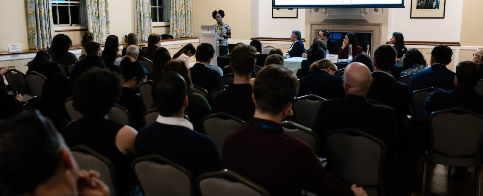 An audience listens to a panel discussing the future of social cohesion.