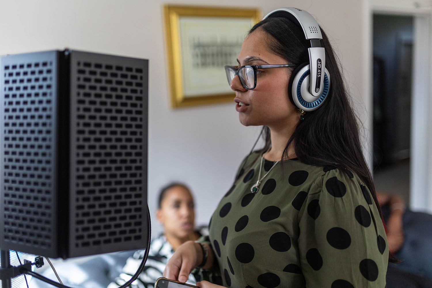 Student with headphones on next to speaker