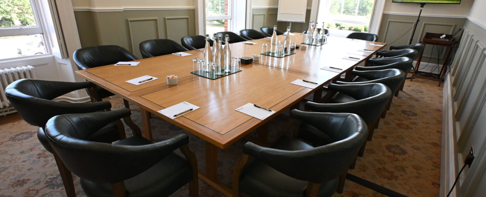 Anderson Room, featuring a long boardroom table with chairs all around it, laid out with notepads and water glasses ready for a meeting