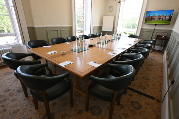 Anderson Room, featuring a long boardroom table with chairs all around it, laid out with notepads and water glasses ready for a meeting